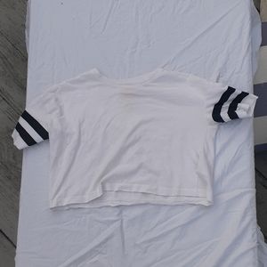 A white crop top with black stripes on the sleeves